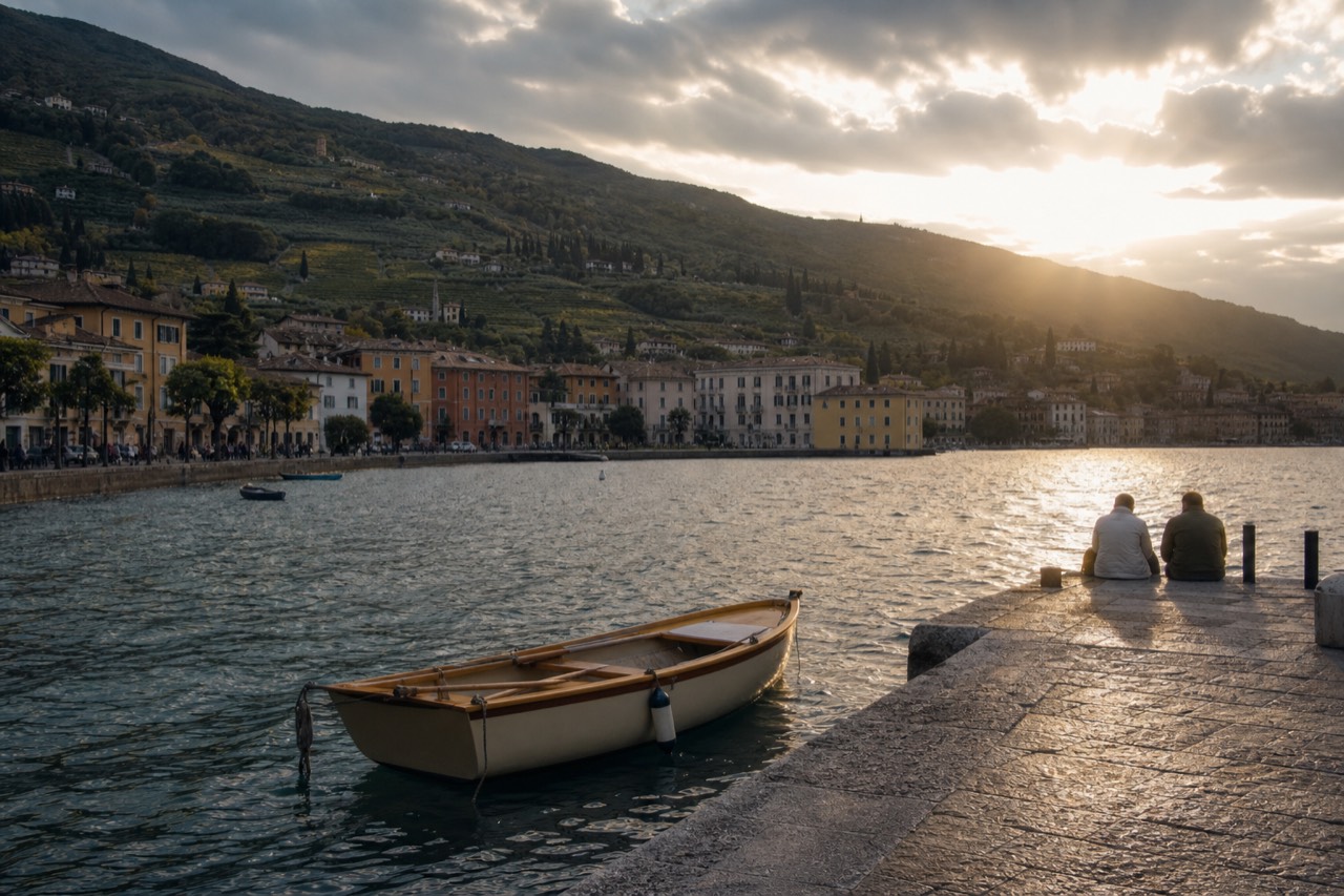 View over Lake Garda with a lakeside town and vineyard hills, no text, no logos, no people.