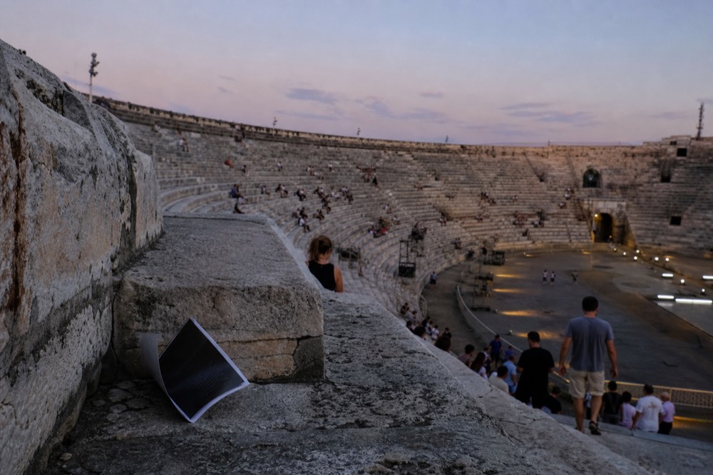 Verona's Roman arena seen from the upper stone tiers at dusk, no text, no logos, no people