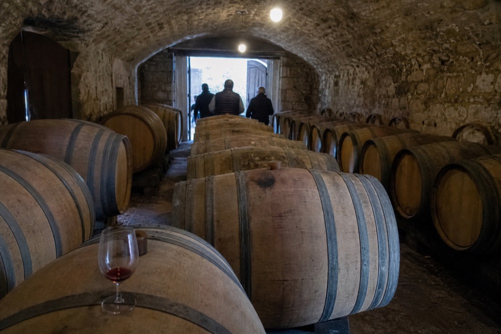 Oak barrels lined up in a historic Valpolicella cellar, no text, no logos, no people