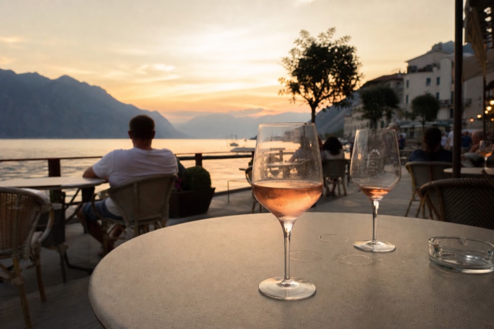 Glass of light red wine on a terrace overlooking Lake Garda, no text, no logos, no people