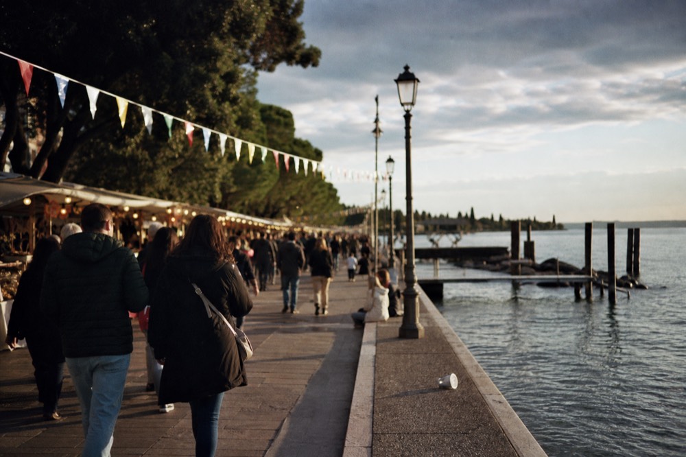Festival stalls and bunting along the Bardolino lakefront, no text, no logos, no people