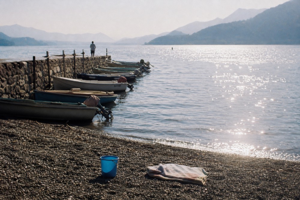 Lake Garda shore with boats and hills, no text, no logos, no people