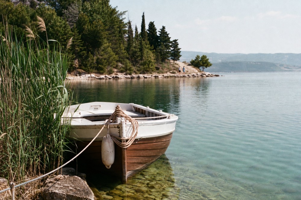 A small historic boat moored on clear water near Sirmione, no text, no logos, no people