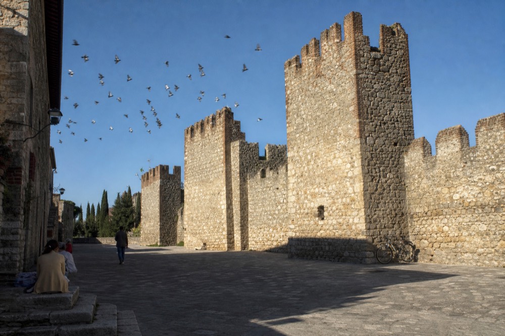 Medieval stone walls and towers of Soave under a clear autumn sky, no text, no logos, no people