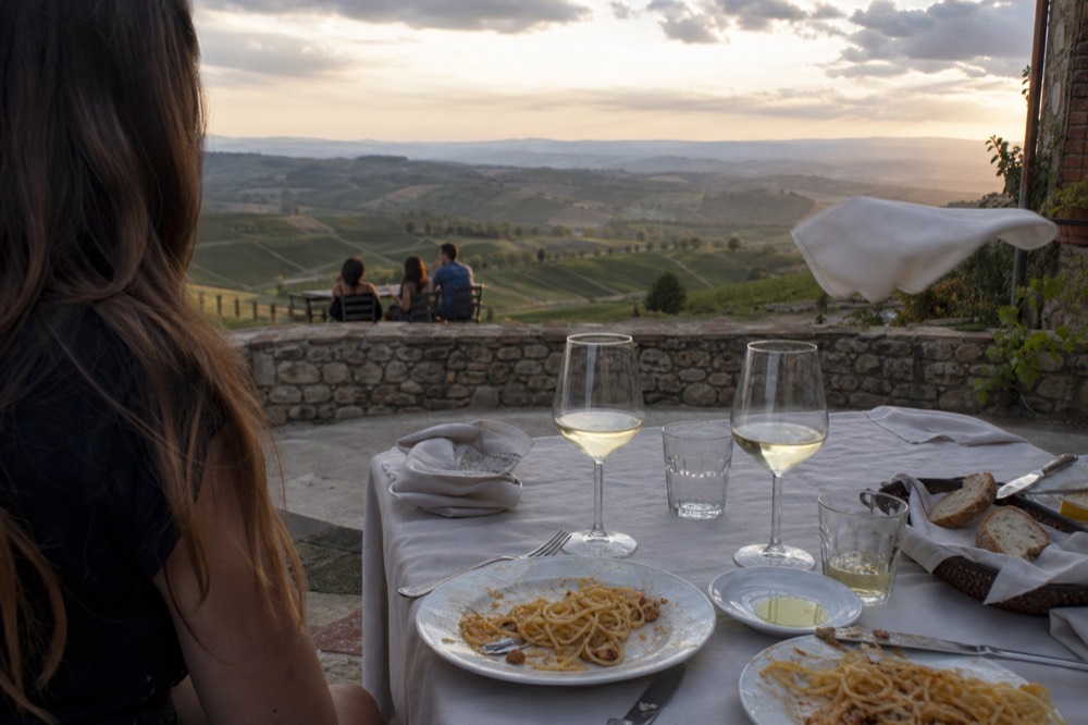 Lunch table with white wine and local dishes on a Soave terrace overlooking vineyards, no text, no logos, no people