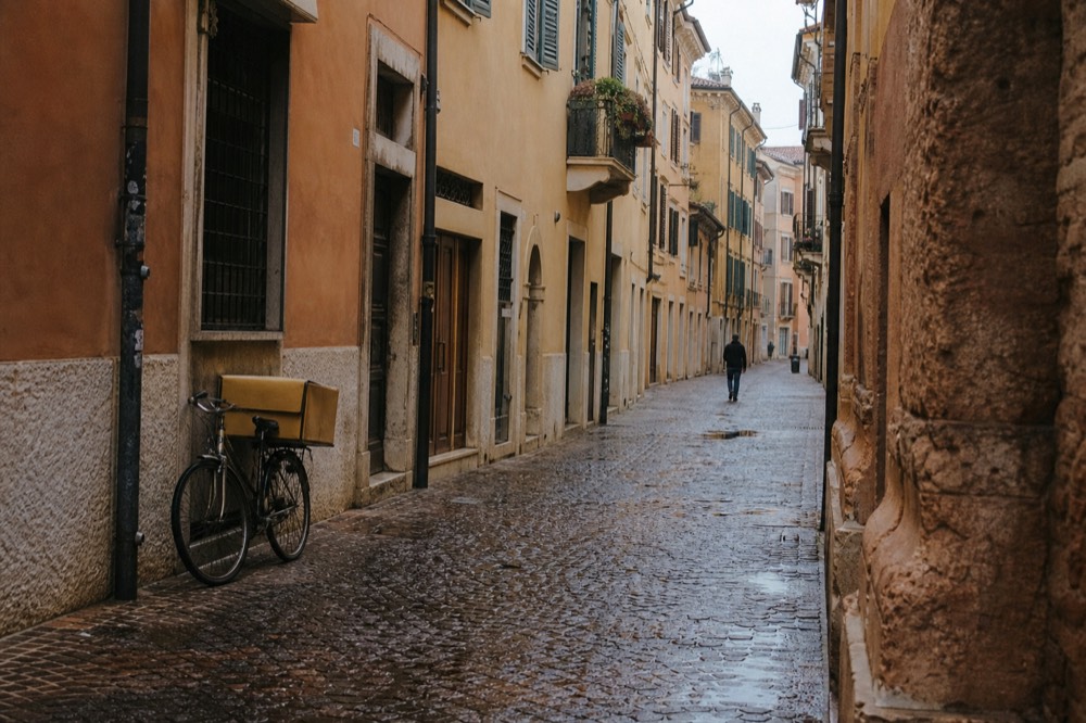 A quiet Verona street with old facades in morning light, no text, no logos, no people
